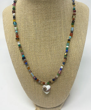 A necklace with a white heart with a gray swirl in the center. It is surrounded by multi color and size beads.