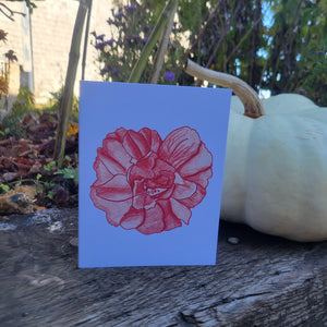 A white card with a large red flower