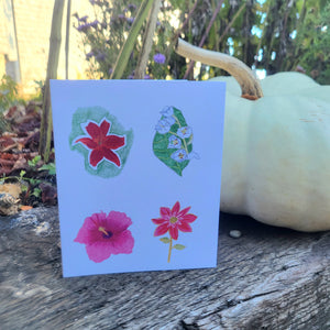 A white card with four different red, pink and white flowers