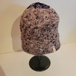 This hat is hand knit with a marbled charcoal and light grey yarn with a bit of purple on top