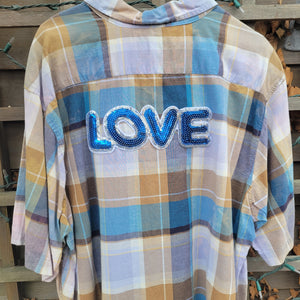 A tan and blue plaid flannel with the word love across it