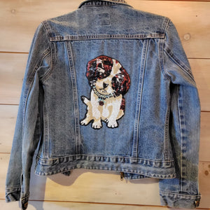A denim jacket featuring brown and tan puppy.
