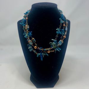 A crystal styled blue bead necklace with bronze beading