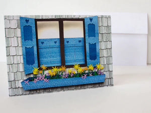 Paper cut depiction of a window box with colorful flowers