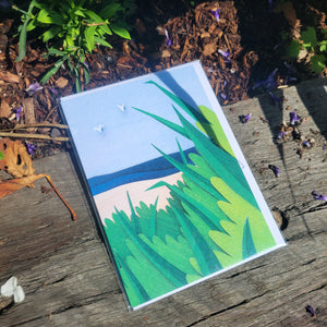Paper cut depiction of beach grass in front of the ocean