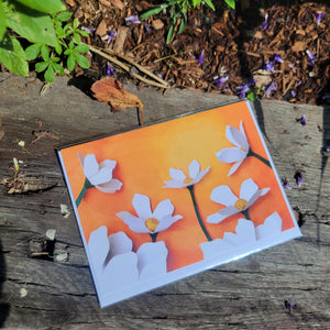 Paper cut depiction of white flowers with an orange background