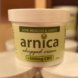 A plastic tub of arnica cream stacked in a spa.
