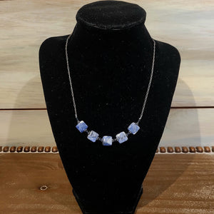 A simple necklace with five square sodalite beads in the middle.