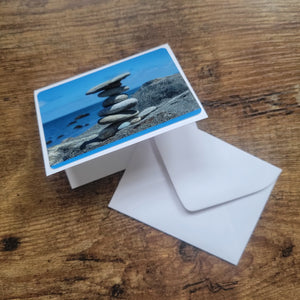 A small card with a picture of a rock sculpture.