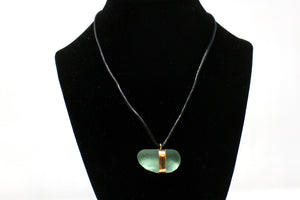 A sea glass necklace with a leather cord.