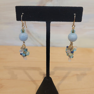 Gold wired earrings with an aqua blue bead followed by a cluster of smaller blue toned beads